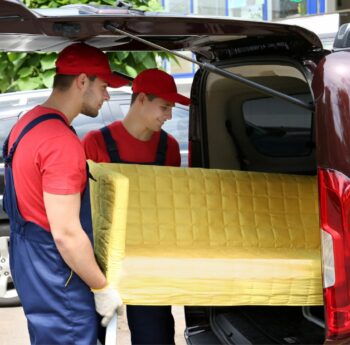 Günstig umziehen in Heidenheim Günstig umziehen in Heidenheim: Umzugshelfer laden ein gelbes Sofa in einen Transporter