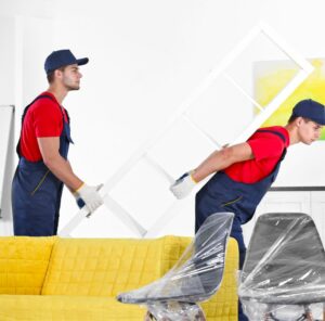 Umzug in Heidenheim Zwei Helfer tragen ein Möbelstück an einem gelben Sofa vorbei – Umzug in Heidenheim