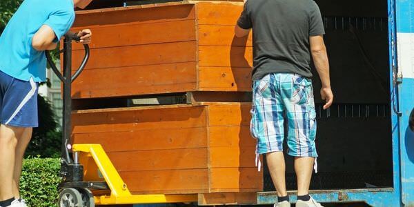 Möbellift Heidenheim: Zwei Helfer tragen einen Holzschrank aus einem Lkw